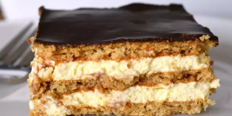 Slice of chocolate éclair cake displaying three layers: golden choux pastry base, creamy vanilla custard filling, and glossy dark chocolate ganache topping on a white plate